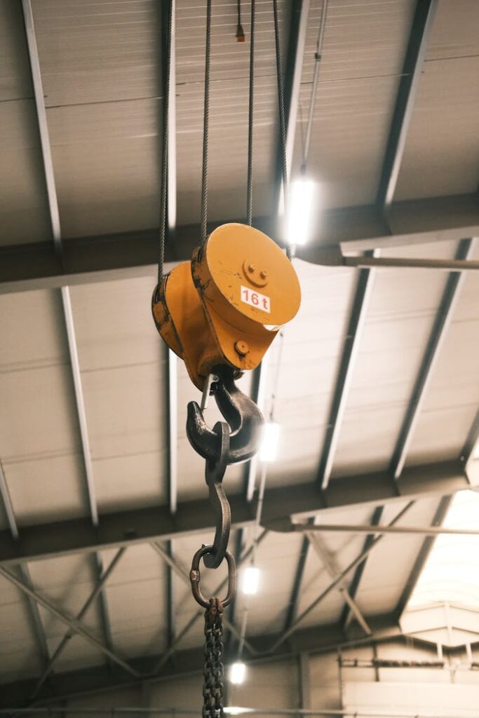 Close-up of a yellow crane hook in an industrial warehouse in Konya, Türkiye.